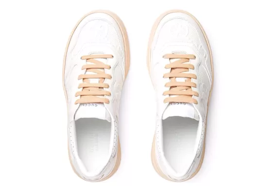Shop Now - Women's Gucci GG Embossed Low-Top Sneakers in White/Peach